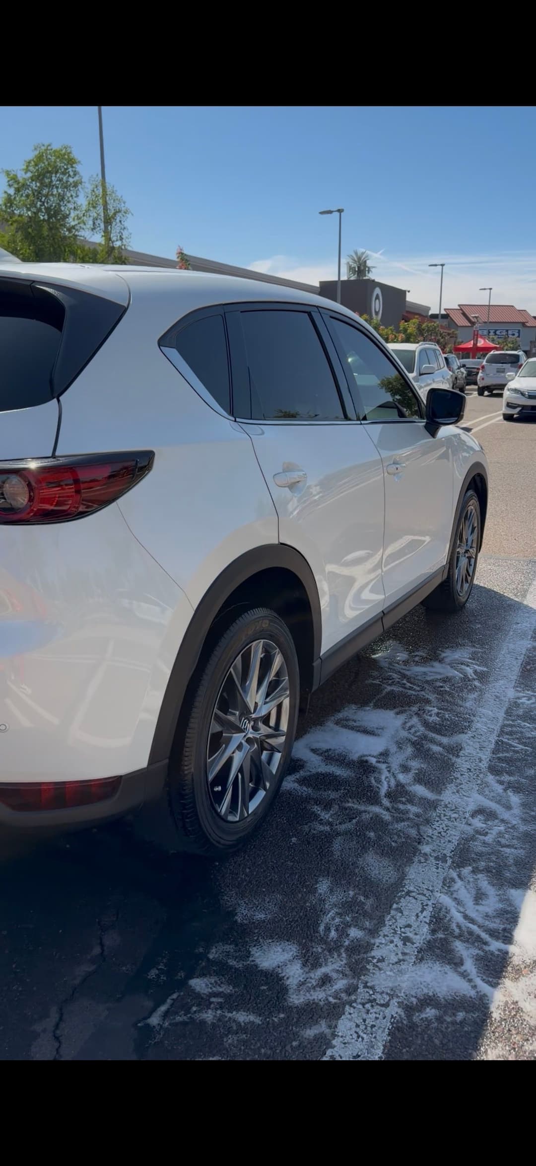 White SUV parked in a lot with soap bubbles on the ground, showcasing a clean exterior.