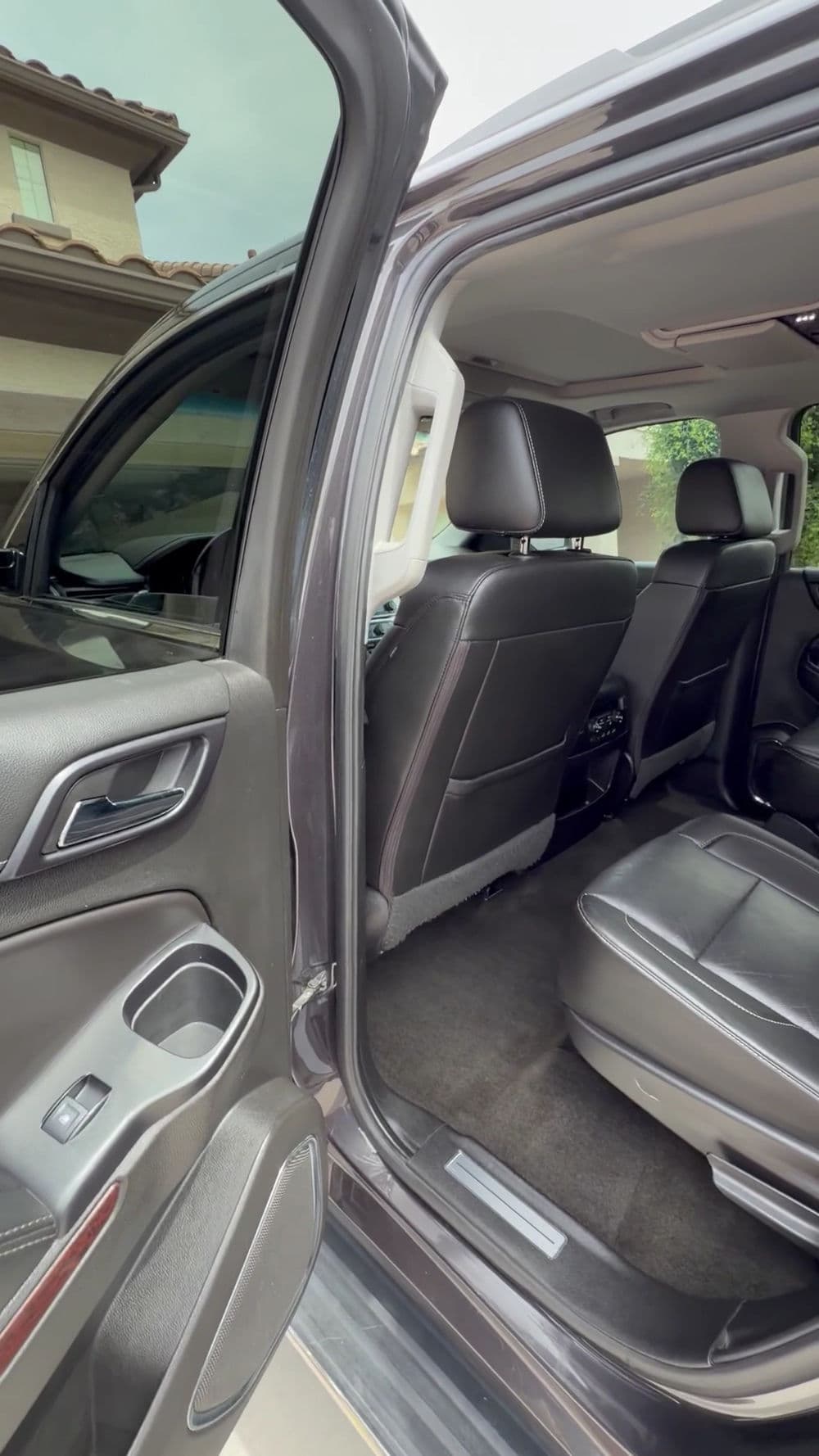 Spacious interior of a modern SUV showcasing black leather seats and open door.
