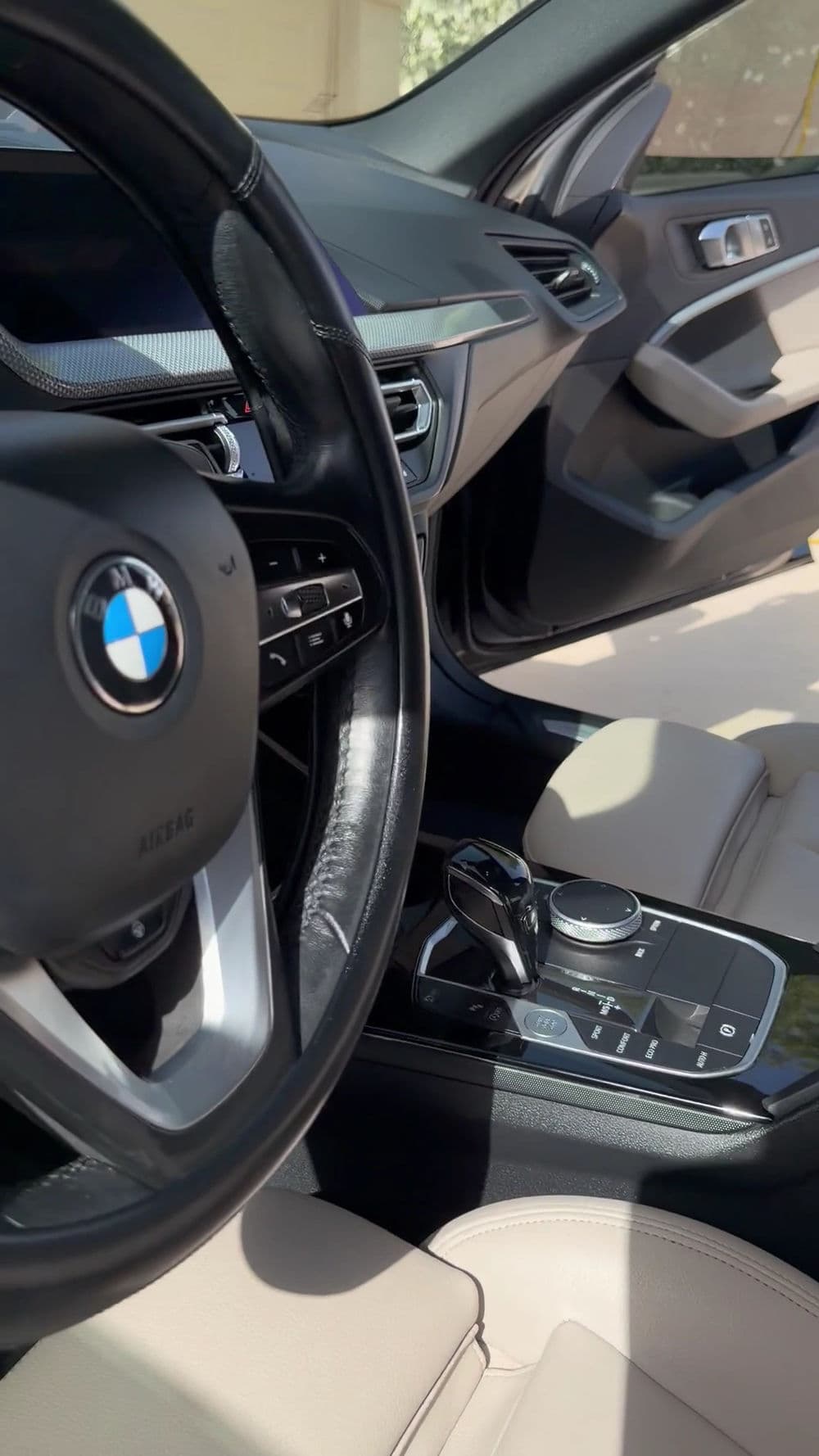 BMW car interior with sleek design, leather steering wheel, and modern control console.