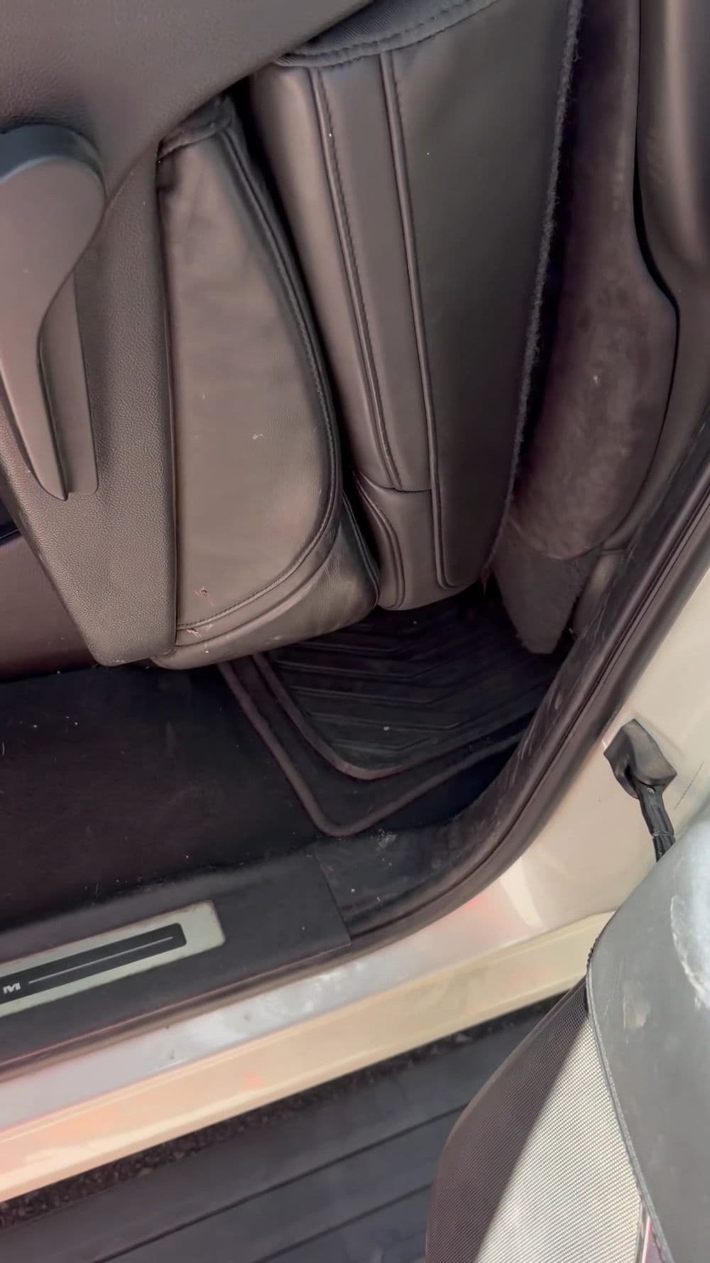 Interior view of a car showcasing the back seat and floor mats.