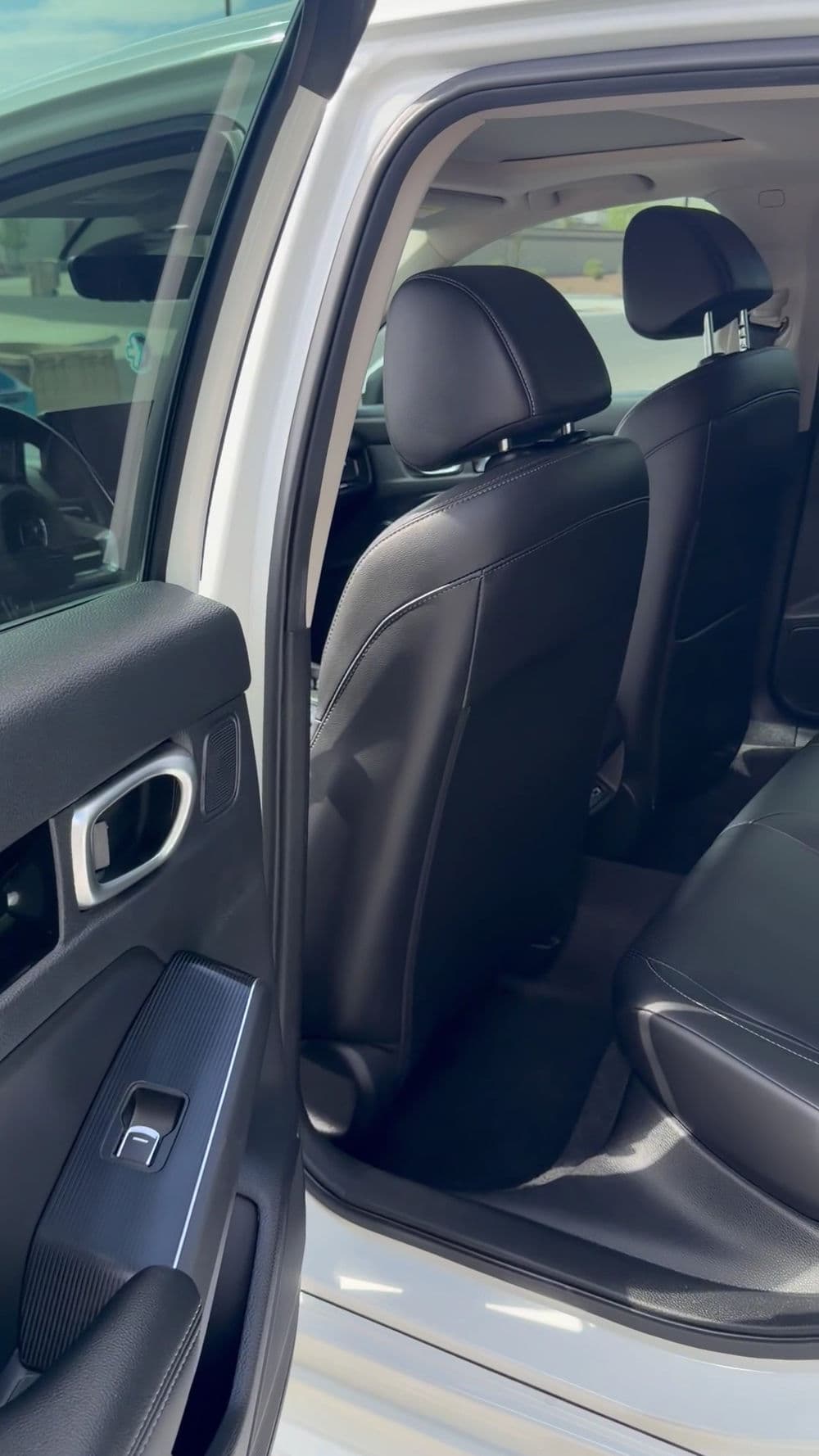 Interior view of a car highlighting rear leather seats and door details.