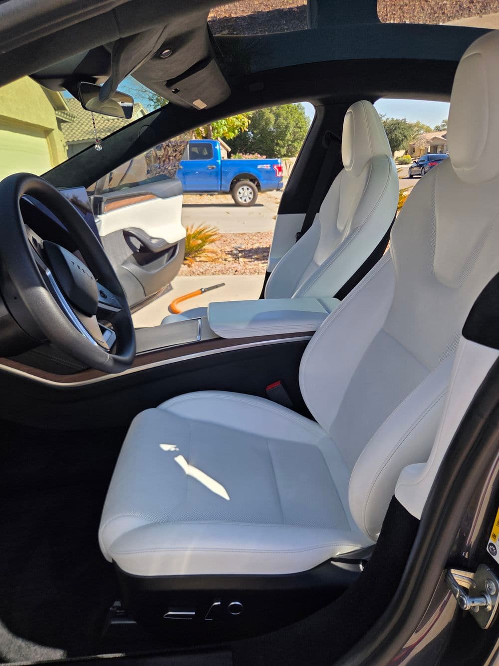 Luxury car interior with white leather seats and modern dashboard design.