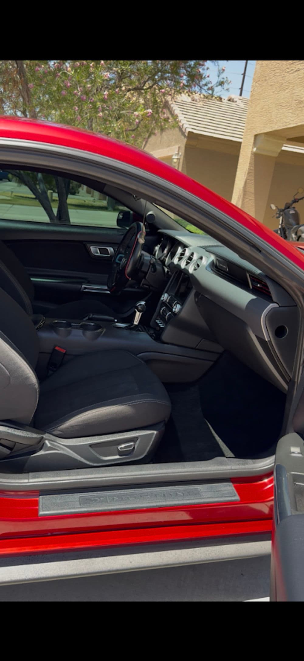 Red car interior showcasing leather seats and modern dashboard design.