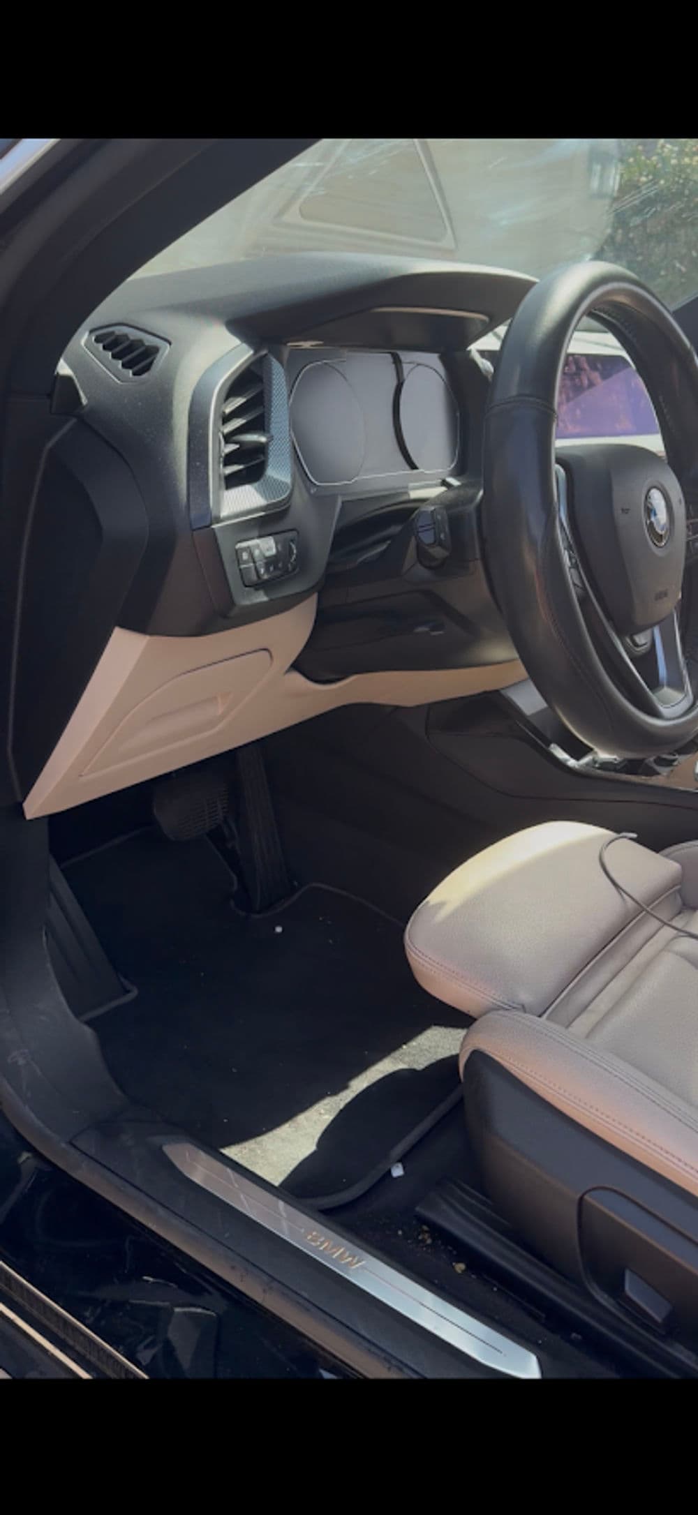 Interior of a car showing dashboard, steering wheel, and leather seats.