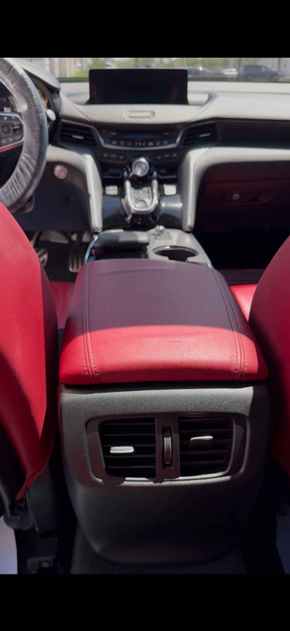 Luxurious car interior featuring red leather seats and a stylish console design.