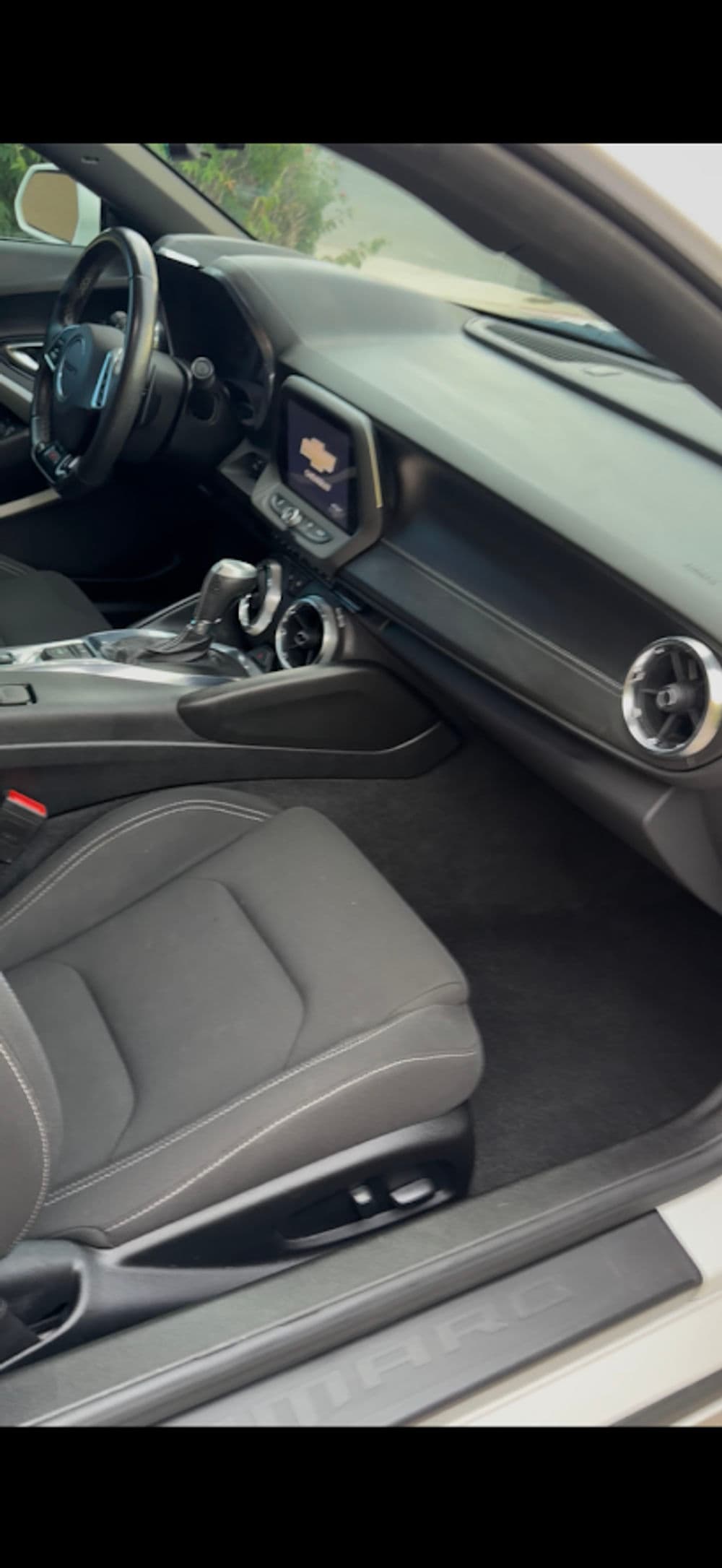 Interior view of a modern car featuring black leather seats and a sleek dashboard with touchscreen.